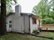 Exterior view of the home with a wooden deck, siding, chimney, and wooded backyard at 4675 N Herbemont Rd, Martinsville, IN 46151