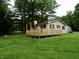 Charming home featuring a large wooden deck, surrounded by lush greenery and mature trees at 4675 N Herbemont Rd, Martinsville, IN 46151