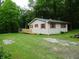 A charming one-story home with a wooden deck surrounded by a lush green lawn and mature trees at 4675 N Herbemont Rd, Martinsville, IN 46151
