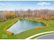 Scenic aerial view of a tranquil pond surrounded by lush landscaping, enhancing the community's natural beauty at 469 Hidden Hills Way, Pittsboro, IN 46167