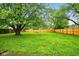 Spacious backyard with a lush green lawn, mature trees, and a wooden fence for privacy at 4701 Candy Spots Dr, Indianapolis, IN 46237