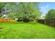 Expansive backyard with lush green lawn, mature trees, and a charming wooden fence at 4701 Candy Spots Dr, Indianapolis, IN 46237
