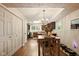 Well-lit dining room with hardwood floors and a dining table set for four, and a view into the kitchen at 4701 Candy Spots Dr, Indianapolis, IN 46237