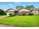 Inviting front of brick home with green lawn, landscaped beds, and blue front door at 4701 Candy Spots Dr, Indianapolis, IN 46237
