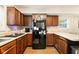 Efficient kitchen with wood cabinets, laminate countertop, and black appliance package at 4701 Candy Spots Dr, Indianapolis, IN 46237