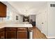 Open-concept kitchen featuring light countertops, wood cabinets, and a view into the dining area at 4701 Candy Spots Dr, Indianapolis, IN 46237