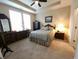 Cozy bedroom with neutral carpet, ceiling fan, tray ceiling, dresser and queen-size bed at 4960 Silverbell Dr, Plainfield, IN 46168