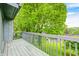 Relaxing covered balcony with wood flooring and railing overlooking lush green trees at 5097 Vantage Point Rd # B 2, Avon, IN 46123