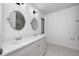 Bathroom with double vanity, round mirrors, and marble floors at 5097 Vantage Point Rd # B 2, Avon, IN 46123