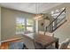 Dining room with a modern chandelier, wood table and seating for six and view of rod iron stairs at 5640 High Vista Cir, Indianapolis, IN 46234