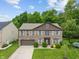 Aerial view of brick home with lush lawn, mature landscaping, and driveway at 5640 High Vista Cir, Indianapolis, IN 46234