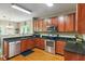 Kitchen with stainless steel appliances, granite countertops, and warm wood cabinets at 5640 High Vista Cir, Indianapolis, IN 46234