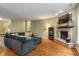 Living room boasts a cozy stone fireplace, dark blue sectional, and hardwood floors at 5640 High Vista Cir, Indianapolis, IN 46234