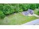 Aerial view of home with lake view lot, lush greenery, fire pit and attached two-car garage at 5739 Paradise Dr, Martinsville, IN 46151