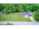 Aerial view of home with lake view lot, lush greenery, fire pit and attached two-car garage at 5739 Paradise Dr, Martinsville, IN 46151