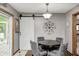 Cozy dining nook featuring a stylish sliding barn door and round table at 5739 Paradise Dr, Martinsville, IN 46151