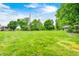 Expansive green lawn leading to the property with mature trees at 5739 Paradise Dr, Martinsville, IN 46151