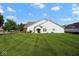 Expansive backyard view showcasing lush green grass and the rear elevation of the home under a bright blue sky at 6105 Franklin Villas Way, Indianapolis, IN 46237