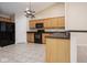 Functional kitchen featuring oak cabinets, black appliances, and neutral tile flooring at 6105 Franklin Villas Way, Indianapolis, IN 46237