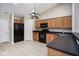 Bright kitchen with oak cabinetry, black appliances, tile flooring, and ample counter space at 6105 Franklin Villas Way, Indianapolis, IN 46237