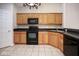 Kitchen featuring wood cabinetry, tile flooring, and black appliances at 6105 Franklin Villas Way, Indianapolis, IN 46237
