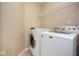 A well-lit laundry room features a washer, dryer, wire shelving, and neutral walls at 6105 Franklin Villas Way, Indianapolis, IN 46237