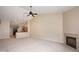 Living room with a fireplace, high ceilings, ceiling fan, and view into kitchen at 6105 Franklin Villas Way, Indianapolis, IN 46237