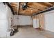 Unfinished basement area showcasing exposed pipes, a refrigerator, and white plastic sheeting at 6337 Ederline Ln, Noblesville, IN 46062