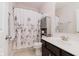 Well-lit bathroom with floral shower curtain, vanity, and linen storage at 6337 Ederline Ln, Noblesville, IN 46062