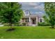 Inviting home featuring a covered porch, stone accents, manicured lawn, and mature trees at 6337 Ederline Ln, Noblesville, IN 46062
