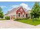 Beautiful home showcasing a side-entry garage, stone and red siding, and manicured lawn at 6337 Ederline Ln, Noblesville, IN 46062
