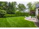 Spacious backyard with lush lawn, mature trees, and a cozy seating area for outdoor enjoyment at 6450 Holliday E Dr, Indianapolis, IN 46260