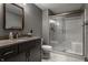 Modern bathroom showcasing a glass-enclosed shower and vanity with a marble countertop at 6450 Holliday E Dr, Indianapolis, IN 46260