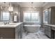 Elegant bathroom with a soaking tub, marble floors, and custom gray cabinetry at 6450 Holliday E Dr, Indianapolis, IN 46260