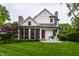 Charming home exterior with a lush lawn, screened-in porch, and patio seating area at 6450 Holliday E Dr, Indianapolis, IN 46260