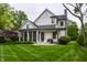 Backyard view of a home with a lush lawn, patio, and a screened-in porch for comfortable outdoor living at 6450 Holliday E Dr, Indianapolis, IN 46260
