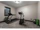 Home gym with treadmill, exercise bike, window, and fitness accessories at 6450 Holliday E Dr, Indianapolis, IN 46260