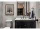 Stylish powder room featuring a black vanity with marble countertop and gold fixtures at 6450 Holliday E Dr, Indianapolis, IN 46260
