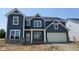 Charming two-story home with blue siding, white trim, and a brick base, offering a blend of modern and classic design at 6462 Stone Side Dr, Plainfield, IN 46168