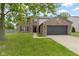 Charming brick home with a two-car garage and a green lawn at 65 Millet Ct, Danville, IN 46122