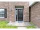 Close-up of a black front door with brick facade, window, and welcome mat at 65 Millet Ct, Danville, IN 46122