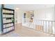 Upstairs hallway with white railing, showing access to other rooms, with a dark bookshelf on the left at 65 Millet Ct, Danville, IN 46122