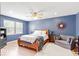 Serene main bedroom featuring blue walls, wood floors, and soft natural light from a side window at 65 Millet Ct, Danville, IN 46122