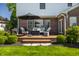 Outdoor deck with cozy seating, a fire pit table, lush green lawn, and well-maintained landscaping at 6649 Braemar S Ave, Noblesville, IN 46062