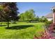 Lush backyard featuring a well-manicured lawn, mature trees, and vibrant flowerbeds, perfect for outdoor enjoyment at 6649 Braemar S Ave, Noblesville, IN 46062
