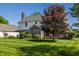 Large backyard showcasing a well-manicured lawn, mature landscaping, and a rear exterior view of the house at 6649 Braemar S Ave, Noblesville, IN 46062
