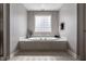 Bright bathroom features a large soaking tub, glass block window, and tiled flooring at 6649 Braemar S Ave, Noblesville, IN 46062