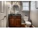 Stylish powder room featuring a dark wood vanity, granite countertop, elegant mirror and decorative lighting at 6649 Braemar S Ave, Noblesville, IN 46062