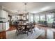 Bright dining area with hardwood floors, chandelier, and adjacent kitchen at 6649 Braemar S Ave, Noblesville, IN 46062