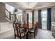 Formal dining area featuring an elegant table, wainscoting, modern lighting, and large windows with blue drapes at 6649 Braemar S Ave, Noblesville, IN 46062